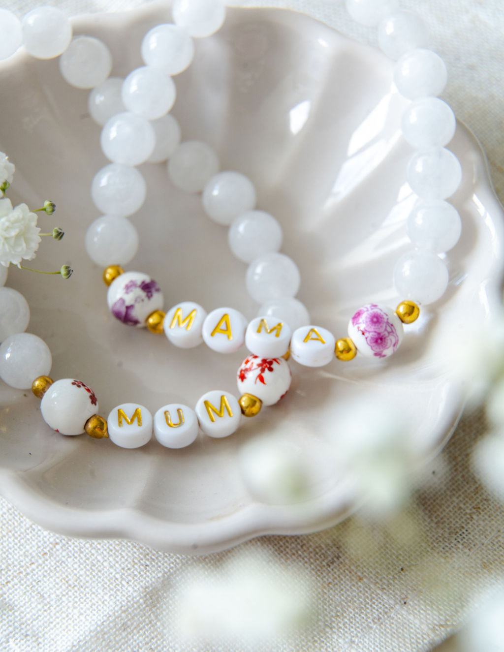Handmade beaded bracelets spelling MUM and MAMA with white gemstone beads and floral accent beads, meaningful jewellery gifts for mums and Mother’s Day.