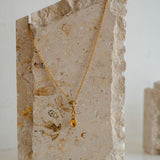 Lovespoon Gold necklace with a pendant on a stone surface