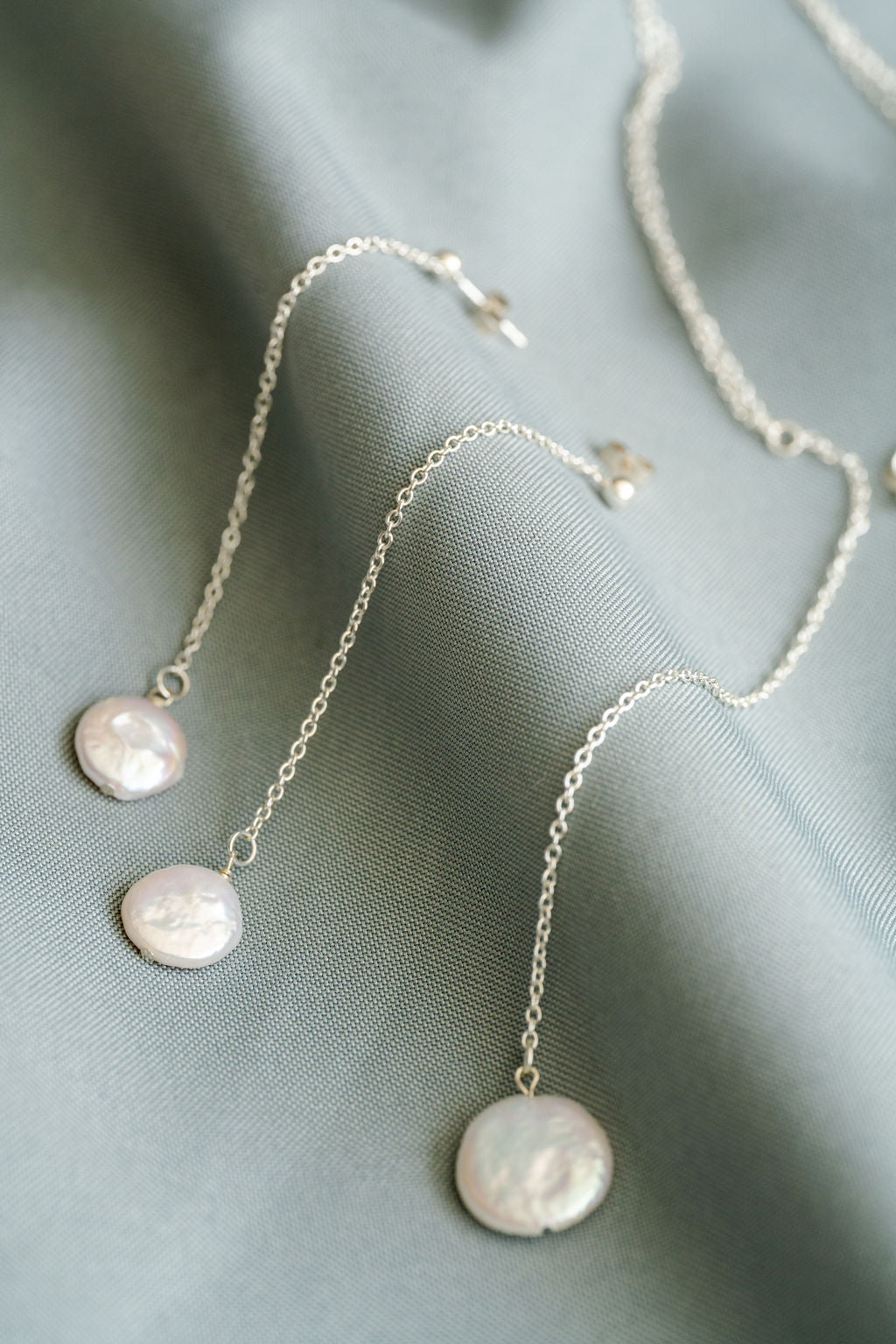 Necklace with pearl pendants on a soft fabric background