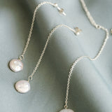 Necklace with pearl pendants on a soft fabric background
