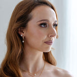 Woman wearing gold jewelry against a white background
