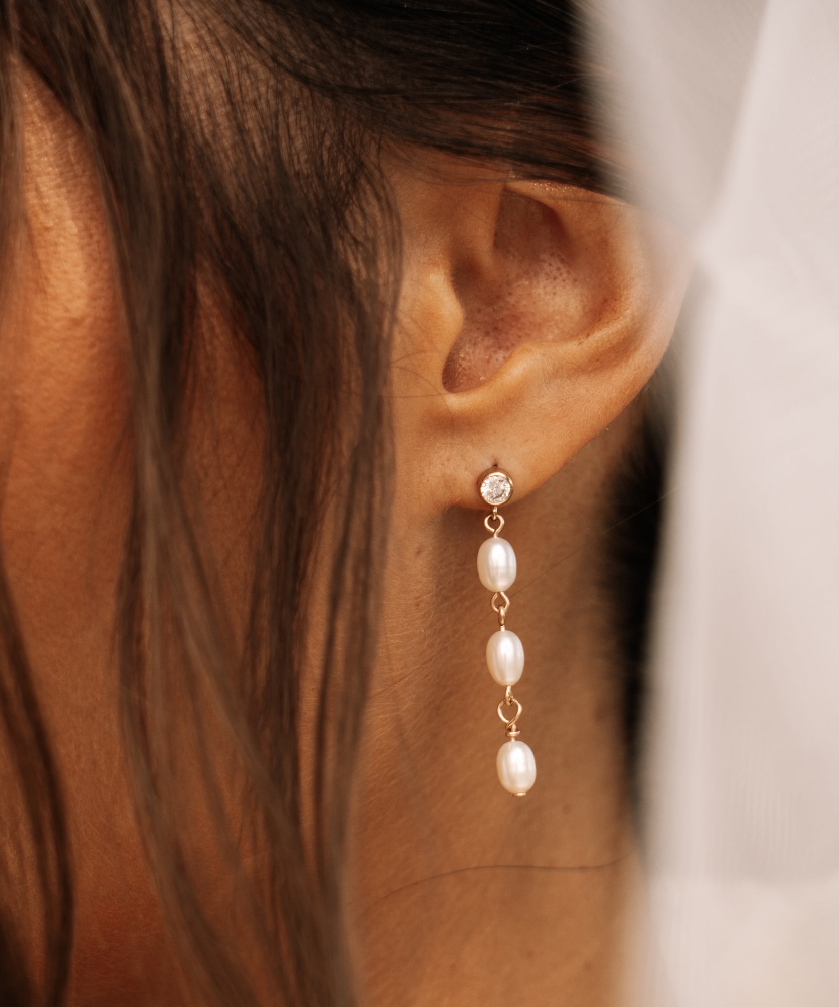 close up of kya pearl drop earrings with cubic zirconia stone 