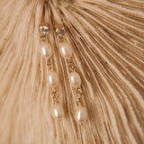 Close up dangling cubic zirconia and rice pearl earrings