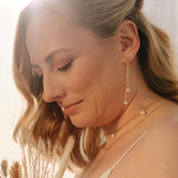 Bride wearing handmade pearl drop earrings and matching pearl necklace, elegant wedding jewellery set styled for a modern bridal look.