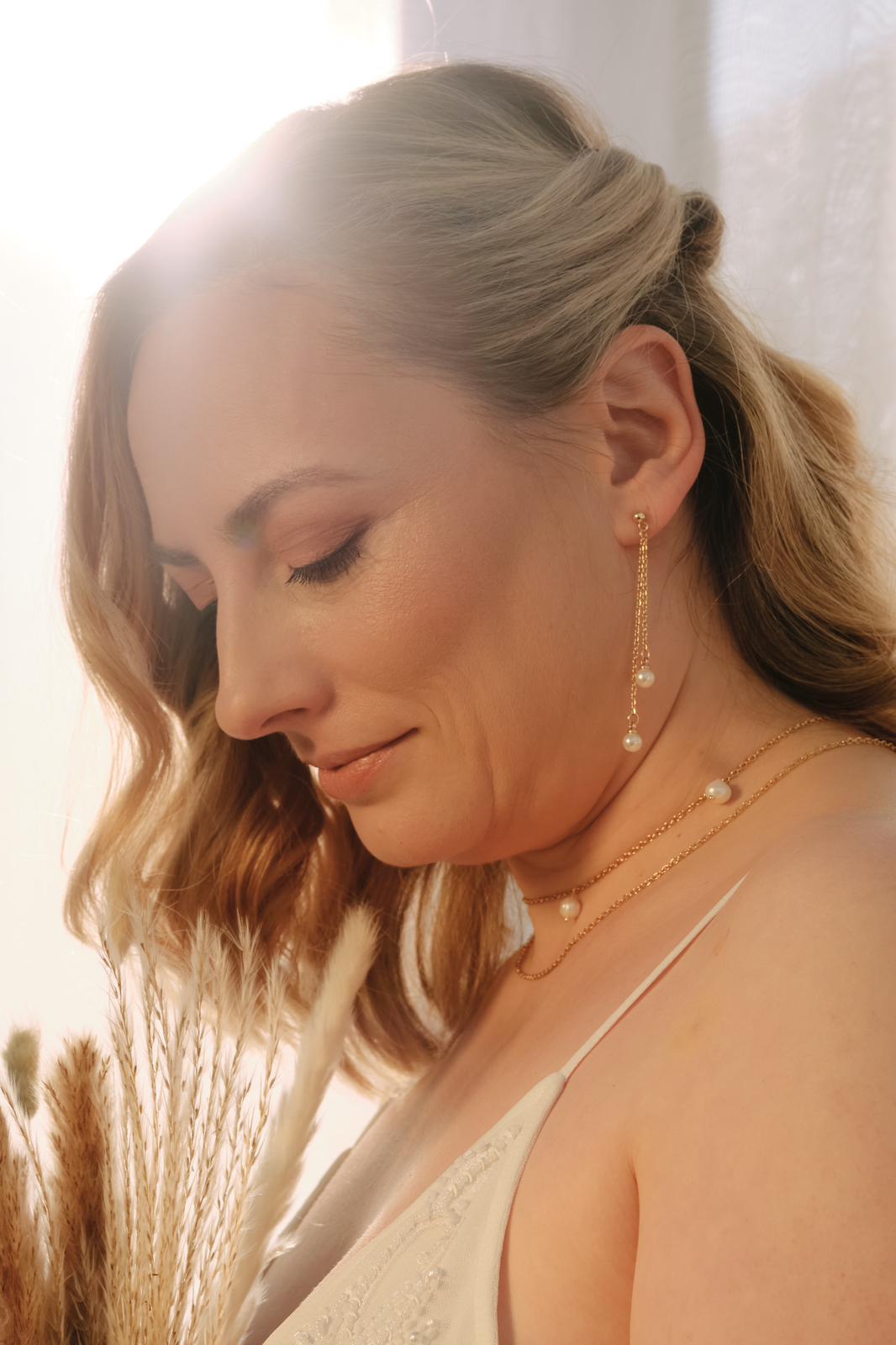 Bride wearing handmade pearl drop earrings and matching pearl necklace, elegant wedding jewellery set styled for a modern bridal look.