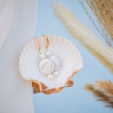Gold hook bridal earrings with natural pearls, styled in a seashell, elegant handmade wedding jewellery perfect for brides and bridesmaids.