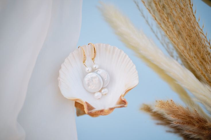 Gold hook bridal earrings with natural pearls, styled in a seashell, elegant handmade wedding jewellery perfect for brides and bridesmaids.