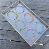 Collection of handmade beaded bracelets in pastel colours with BRIDE and BRIDESMAID letter beads, perfect personalised jewellery gifts for the bridal party.