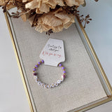 Purple beaded bridesmaid bracelet with gold accents and BRIDESMAID letter beads, displayed on a proposal card reading “Will you be my bridesmaid?”, a thoughtful wedding party gift.