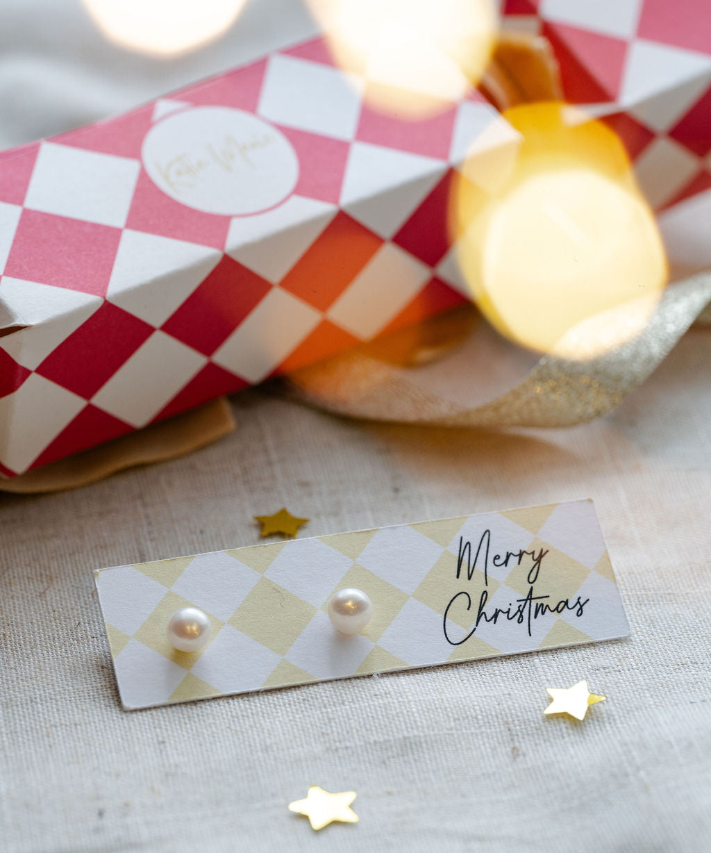 pearl earrings studs on merry christmas stationary. 