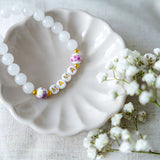 Handmade mama bracelet with white gemstone beads and gold letter beads spelling MAMA, a thoughtful jewellery gift for new mums or Mother’s Day.