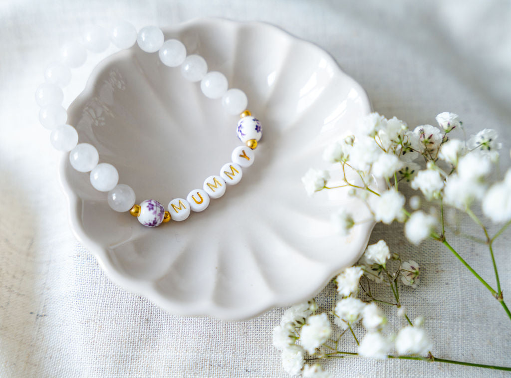 Handmade mummy bracelet with white gemstone beads and gold letter beads spelling MUMMY, a thoughtful handmade jewellery gift for mums and Mother’s Day.